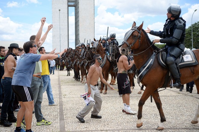 Pessoas protestam a presença da cavalaria da polícia, durante manifesto em Brasília, DF, nesta quinta (17). Foto: | Andressa Anholete/AFP