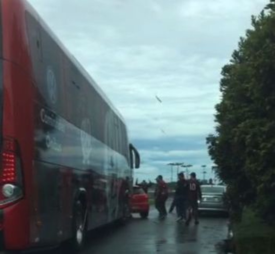 Grupo aborda ônibus a caminho do aeroporto, em frente ao CT. Paus e pedras foram  arremessadas. | /Reprodução