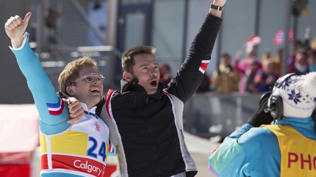 Eddie “the Eagle” Edwards, personagem real, e seu treinador fictício, vivido por Hugh Jackman. | Larry Horricks/Divulgação