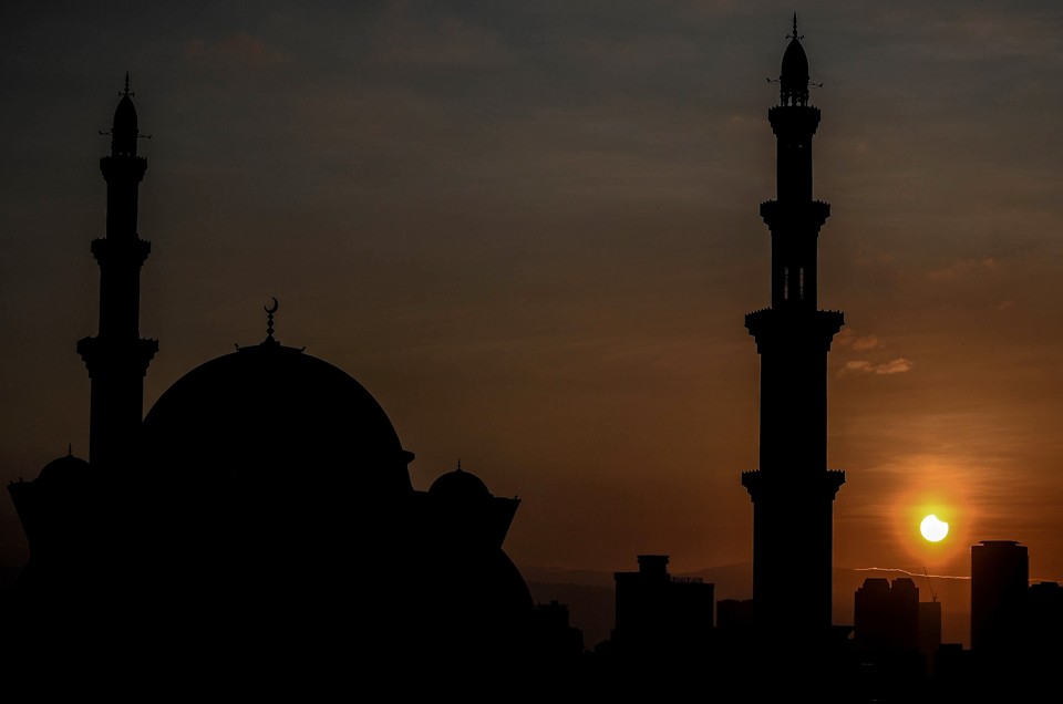 Eclipse solar parcial é viso por trás da mesquita Wilayah, em Kuala Lumpur | MANAN VATSYAYANA/AFP