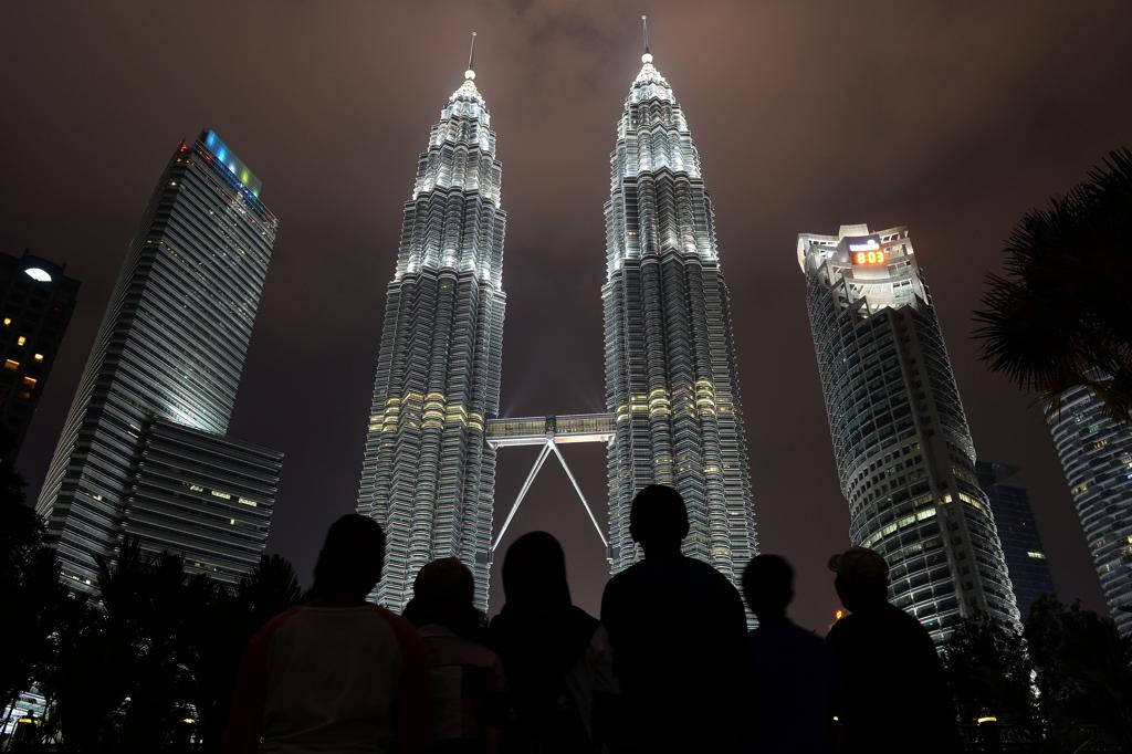 Centenas de pessoas aguardaram o apagar das luzes em frente às Torres Petronas, ícone arquitetônico de Kuala Lumpur, na Malásia | Mohd Rasfan/AFP