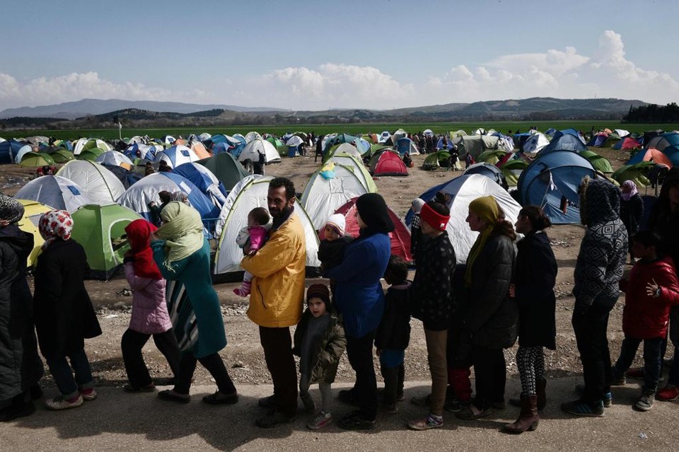Imigrantes e refugiados em campo na fronteira entre Grécia e Macedônia. | Louisa Gouliamaki/AFP