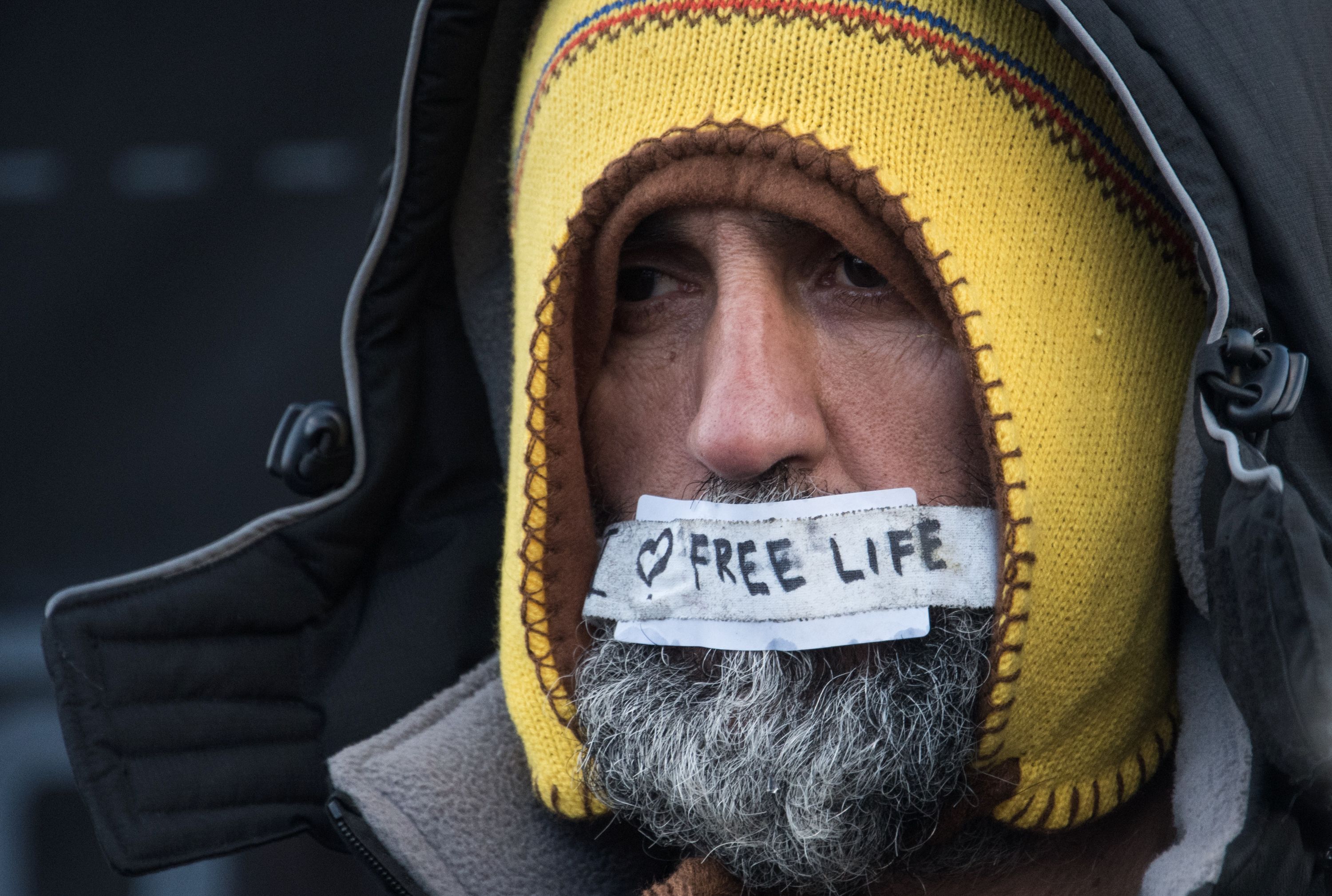 Homem pede ‘vida livre’ em protesto contra o desmantelamento de parte do campo de migrantes de Calais | DENIS CHARLET/AFP