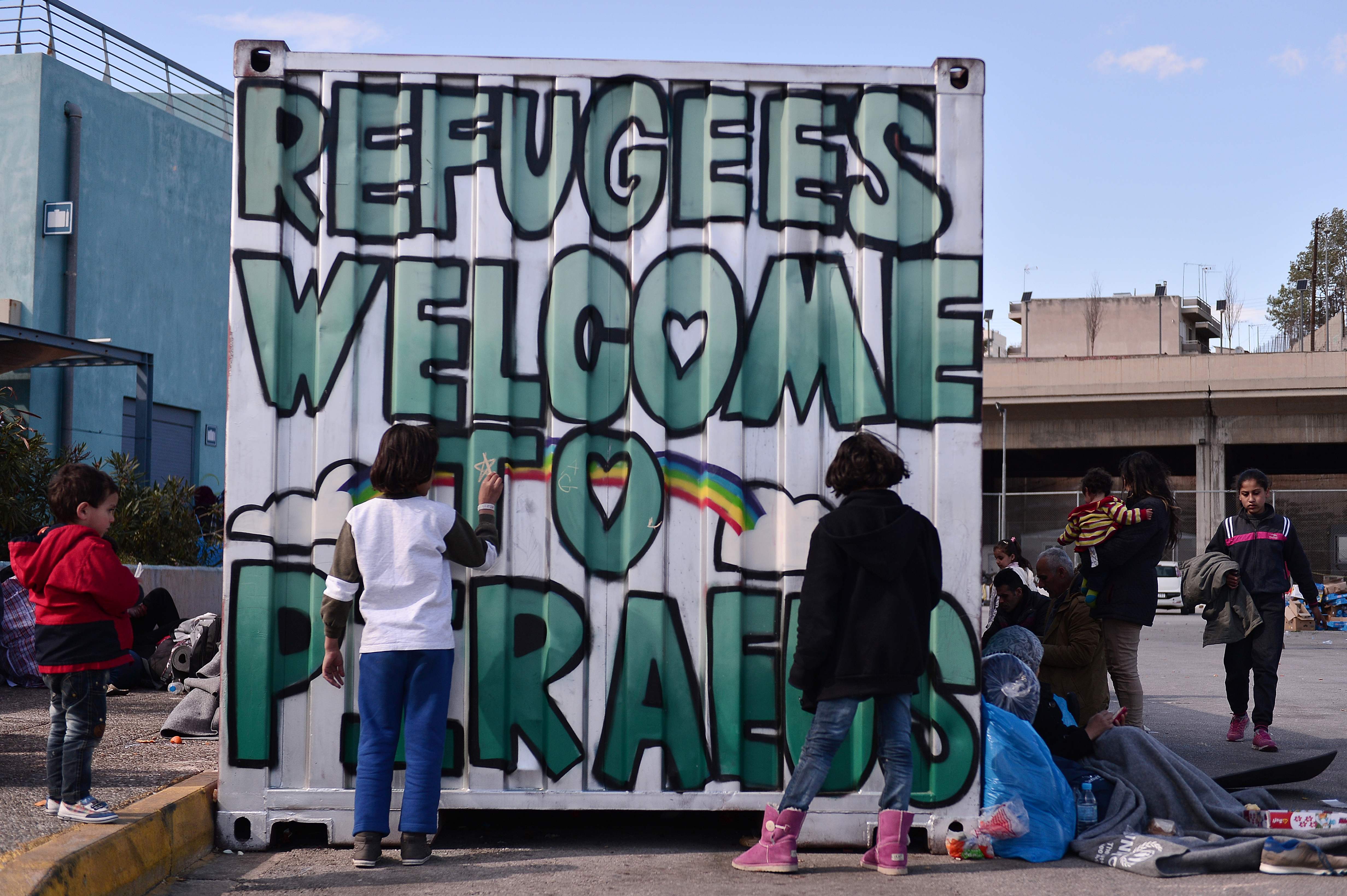 Crianças desenham em contêiner no porto de Piraeus, na Grécia | LOUISA GOULIAMAKI/AFP