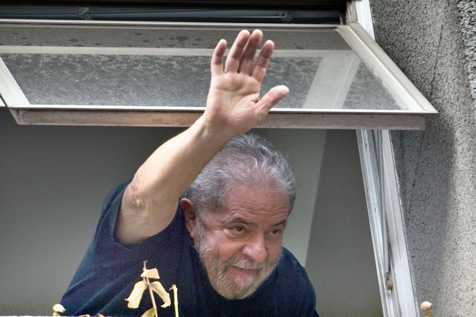 Ex-presidente Lula acena para militantes do PT em frente ao Diretório Nacional do partido, em São Paulo. | Nelson Almeida/AFP