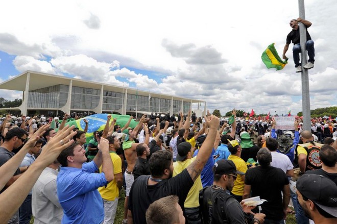 Em Brasília, manifestante contra o governo sobe em poste durante protesto, em frente ao Palácio do Planalto. Foto: | Edilson Rodrigues/Agência Senado