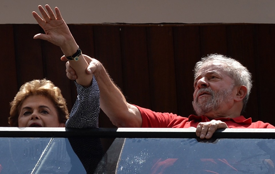 Dilma apareceu de mãos dadas ao lado de Lula na varanda do apartamento dele. | Nelson Almeida/AFP