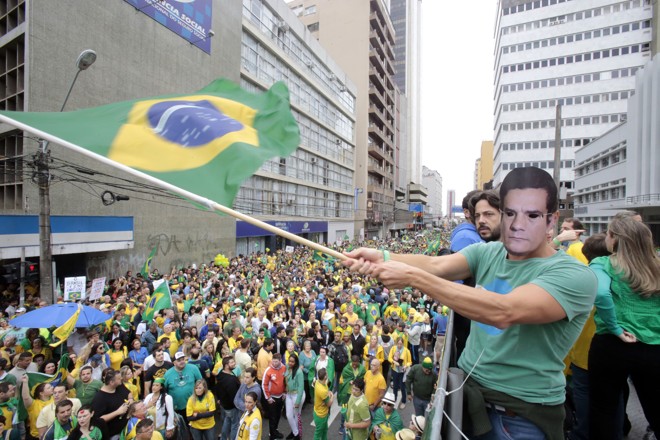 As máscaras dominaram a manifestação na capital paranaense , onde foi até a rua XV de Novembro, terminando na Boca Maldita. Foto: | Pedro Serapio/Gazeta do Povo