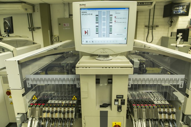 Máquinas compradas de empresas que encerraram atividades (como a Siemens Enterprise Communications, que deixou Curitiba em 2013) fazem a maior parte do trabalho na linha que produz as placas para as câmeras da Pumatronix. | (foto: Marcelo Andrade/Gazeta do Povo)