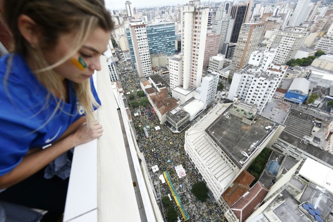 De um prédio na Rua XV, jovem assiste às manifestações | Albari Rosa/Gazeta do Povo