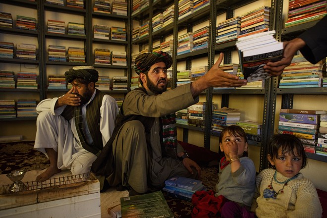 A iniciativa de criar bibliotecas em áreas afegãs em conflito é de Matiullah Wesa, na foto ao centro, com o irmão e as sobrinhas | Andrew Quilty/NYT
