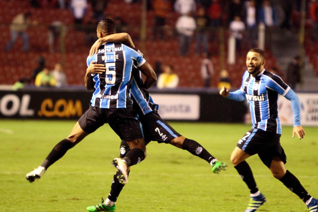 Wallace é abraçado após marcar o terceiro e decisivo gol do Grêmio na altitude de Quito: vitória crucial sobre a LDU. | Javier Cazar/AFP