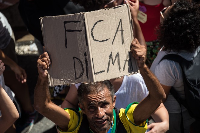 Manifestante contrário ao impeachment segura cartaz na praia de Copacabana, no Rio de Janeiro. | CHRISTOPHE SIMON/AFP