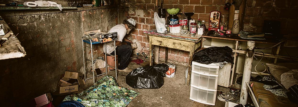 No barracão em que está “preso”, Dirceu* cozinha em um canto do cômodo improvisado: “ a gente come o que tem”. | Hugo Harada/Gazeta do Povo