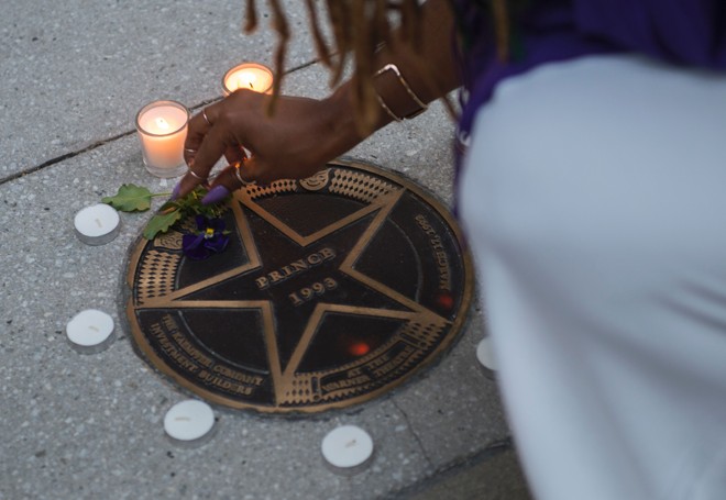 Fã acende vela para o ídolo pop na frente do Teatro Warner, em Washington D.C. | ANDREW CABALLERO-REYNOLDS/AFP