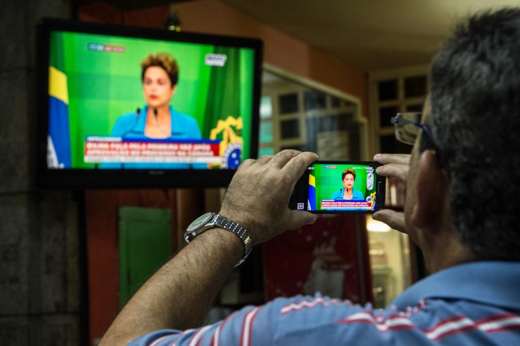 Homem grava discurso da presidente Dilmna Rousseff. | CHRISTOPHE SIMON/AFP