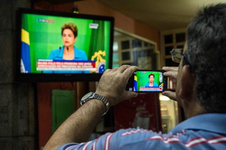 Homem grava discurso da presidente Dilmna Rousseff. | CHRISTOPHE SIMON/AFP