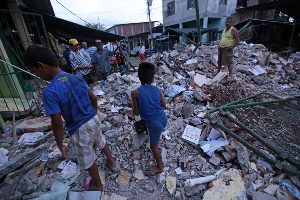 Em Manta, pessoas caminham entre os escombros de casas destruídas pelo terremoto | JUAN CEVALLOS/AFP