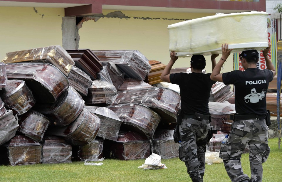Agentes da polícia ajudam a carregar caixões vazios | Rodrigo Buendia/AFP