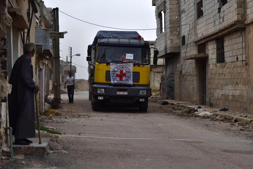 Caminhão da Cruz Vermelha carregando mantimentos chega no vilarejo de rebeldes de Teir Maalah, na Siria. | MAHMOUD TAHA/AFP