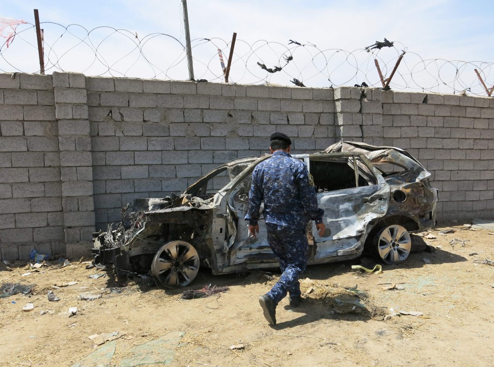 Destroços de um carro que estava no local da explosão cujo alvo era um grupo de peregrinos xiitas | KHALIL AL-MURSHIDI/AFP