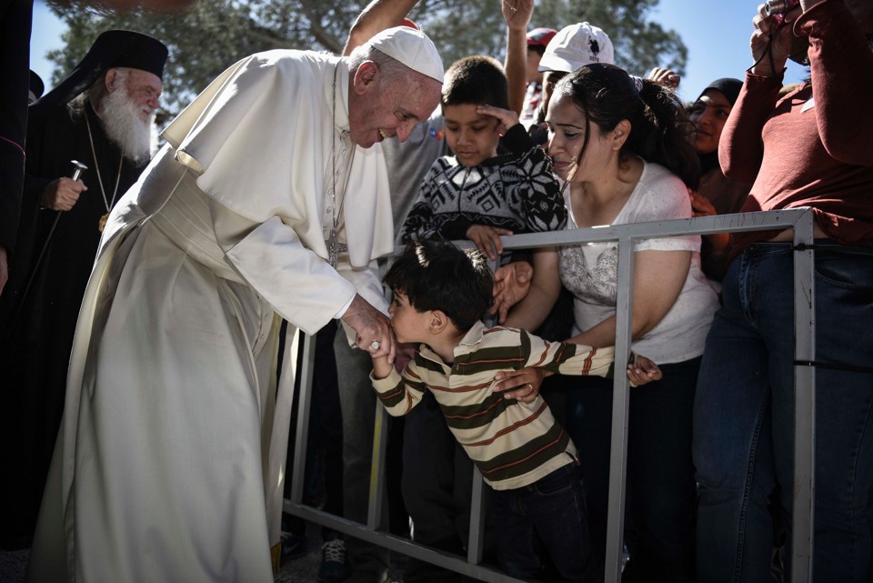 Criança beija a mão do Papa Francisco durante sua visita ao centro de detenção de Moria para migrantes e refugiados , na Ilha de Lesbos | ANDREA BONETTI/AFP