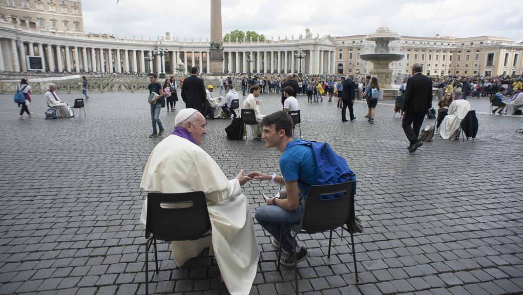 Papa Francisco ouve adolescente na Praça São Pedro, no Vaticano | AFP