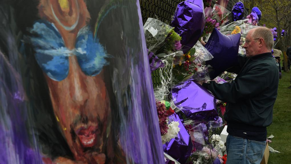 Fã coloca flores em memorial feito em homenagem a Prince em sua cidade natal, Minneapolis | Mark Ralston/AFP