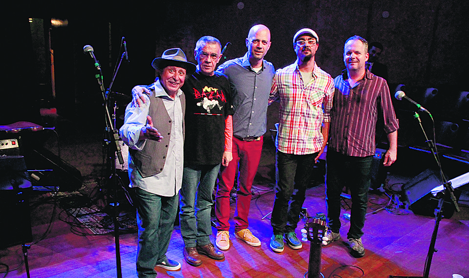 O músico, arranjador e produtor paranaense Reinaldo Godinho (de chapéu) com seus colegas Glauco Sölter (calça vermelha), Márcio Rosa (de xadrez) e Mário Conde (de listrado) e o cartunista e poeta Luiz Antônio Solda, que recitou poemas nos shows realizados nos teatros Positivo e Paiol para lançar o seu mais recente trabalho, “Na Bica da Manhã”. Hoje, o grupo faz mais uma apresentação no Paiol. | Susy Murakami