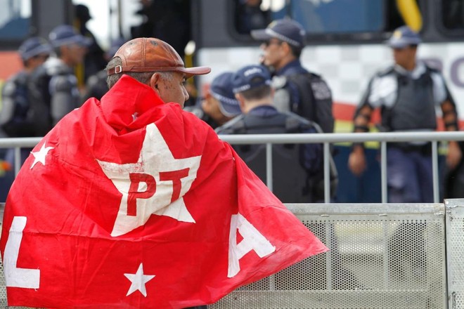 Próximo a barreira de contensão colocada no Congresso Nacional, apoiador de Dilma manifesta seu posicionamento. | BETO BARATA/AFP