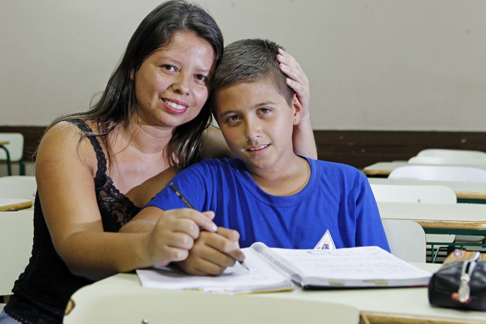 Erick, de 12 anos, com a mãe: adaptações em sala de aula ajudam a melhorar o desempenho | Antônio More/Gazeta do Povo