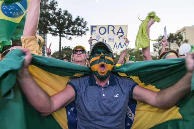 Rosto pintado e bandeira do Brasil: homem mostra apoio ao impeachment | Marcelo Andrade/Gazeta do Povo