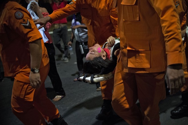 Mulher é fotografada em maca após participar de manifestação contrária ao impeachment de Dilma. | Andressa Anholete/AFP