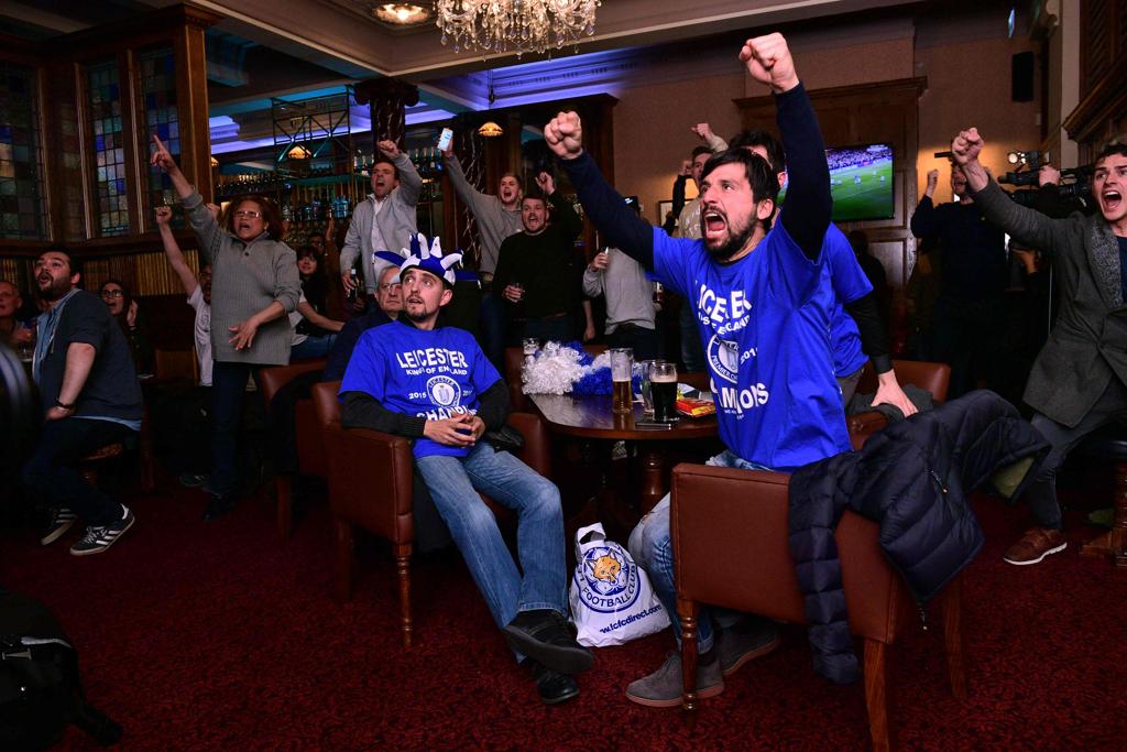 Torcedores do Leicester comemoram o título em pub. | LEON NEAL/AFP