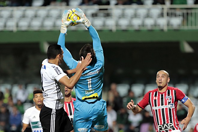O goleiro são-paulino Dênis vai buscar a bola no alto, evitando a finalização coxa-branca.. | Albari Rosa/Gazeta do Povo