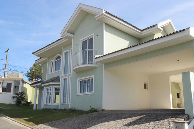 R$ 1.257.600: localizado em Santa Felicidade, em condomínio fechado, o sobrado possui 298 m² construídos e 685,78 m² de área total. O imóvel conta com uma suíte máster com closed, sacada e hidromassagem, um dormitório com suíte e outros dois quartos, todos no piso superior. Sala para dois ambientes com lareira, cozinha e lavabo, todos com piso em porcelanato, despensa e dependência de empregada também integram a planta. Garagem e churrasqueira estão entre os ambientes externos. | Divulgação/Corteze Imóveis