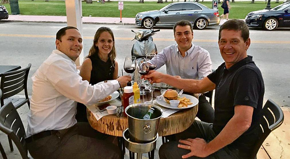 O chef Junior Durski (de camisa escura) comemora o pedido de casamento de sua filha Laysa pelo médico venezuelano Fabio Pereira (1º à esq.) na filial do Madero de Miami, na última quinta-feira. Também na foto, Rafael Mello, concunhado de Durski e sócio do restaurante. | Divulgação