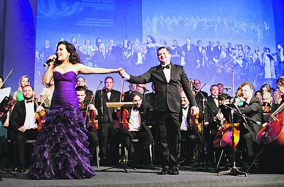A cantora lírica Carmen Monarcha apresentou-se com o Del Chiaro – Coral & Orquestra, regido pelo maestro Gil Gonçalves, na abertura do congresso da Associação Nacional de Medicina do Trabalho, presidido pelo médico paranaense Zuher Handar, domingo, em Foz do Iguaçu. De lá, ela embarcou para a Europa, onde integrará a turnê de André Rieu como convidada especial. | Joao Vanzzo