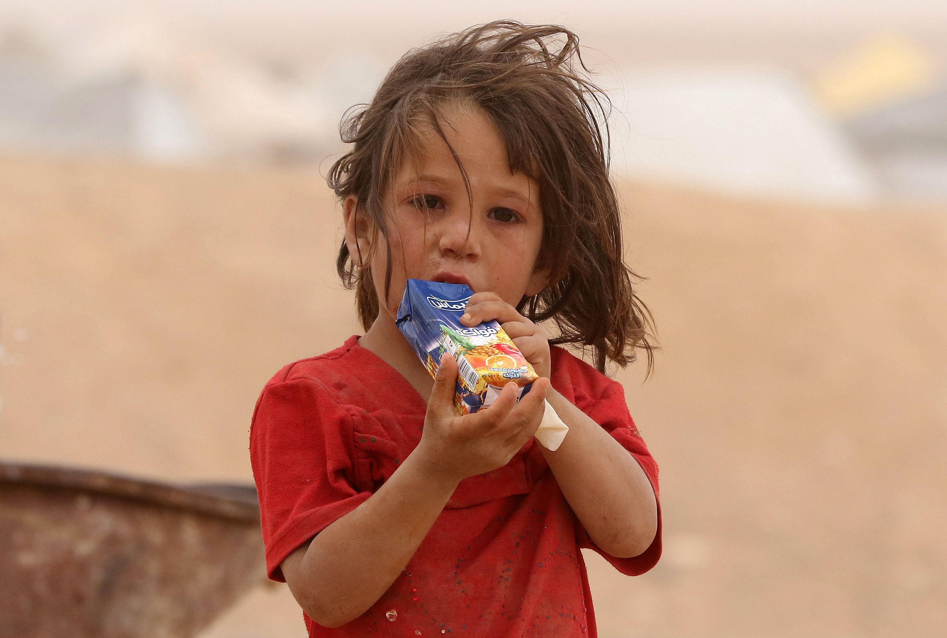 Criança síria espera em Hadalat, na Jordânia: apenas na Síria, mais de 6 mil escolas estão fora de uso | KHALIL MAZRAAWI/AFP