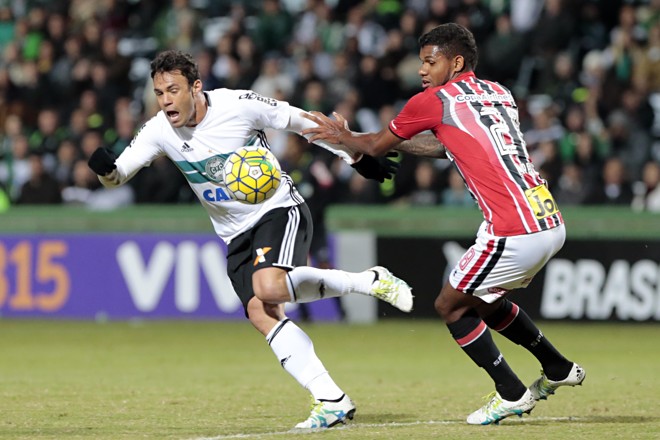 O artilheiro coxa-branca Kléber tenta escapar da marcação do São Paulo, no Couto Pereira. | Albari Rosa/Gazeta do Povo