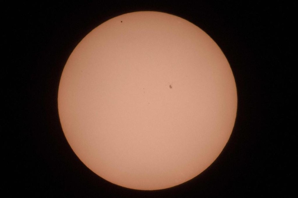 Mercúrio é o pequeno ponto preto no canto superior esquerdo do Sol, nesta imagem captada nesta segunda-feira | MAXIM MALINOVSKY/AFP
