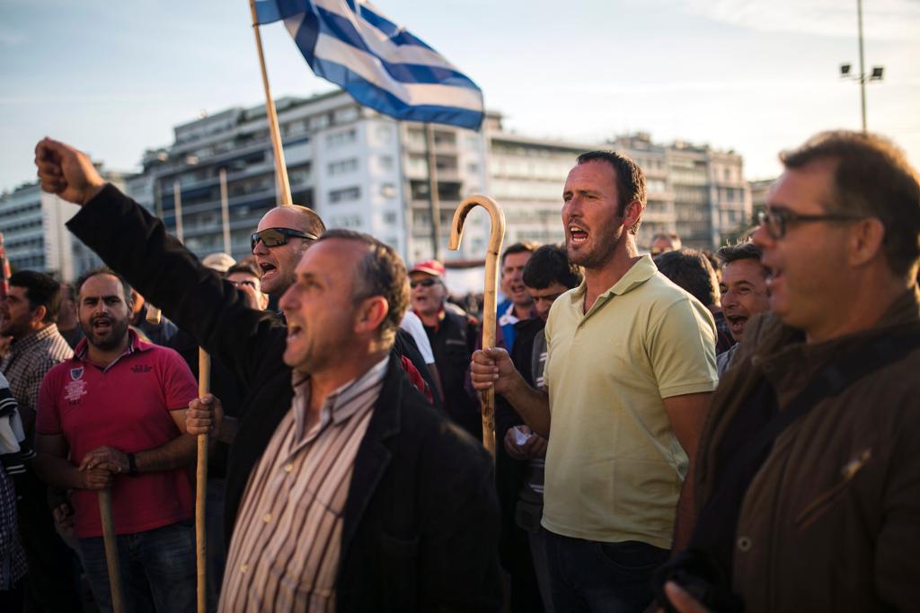Manifestantes contrários à reforma se reuniram em frente ao Parlamento grego neste domingo (8) | ANGELOS TZORTZINIS/AFP
