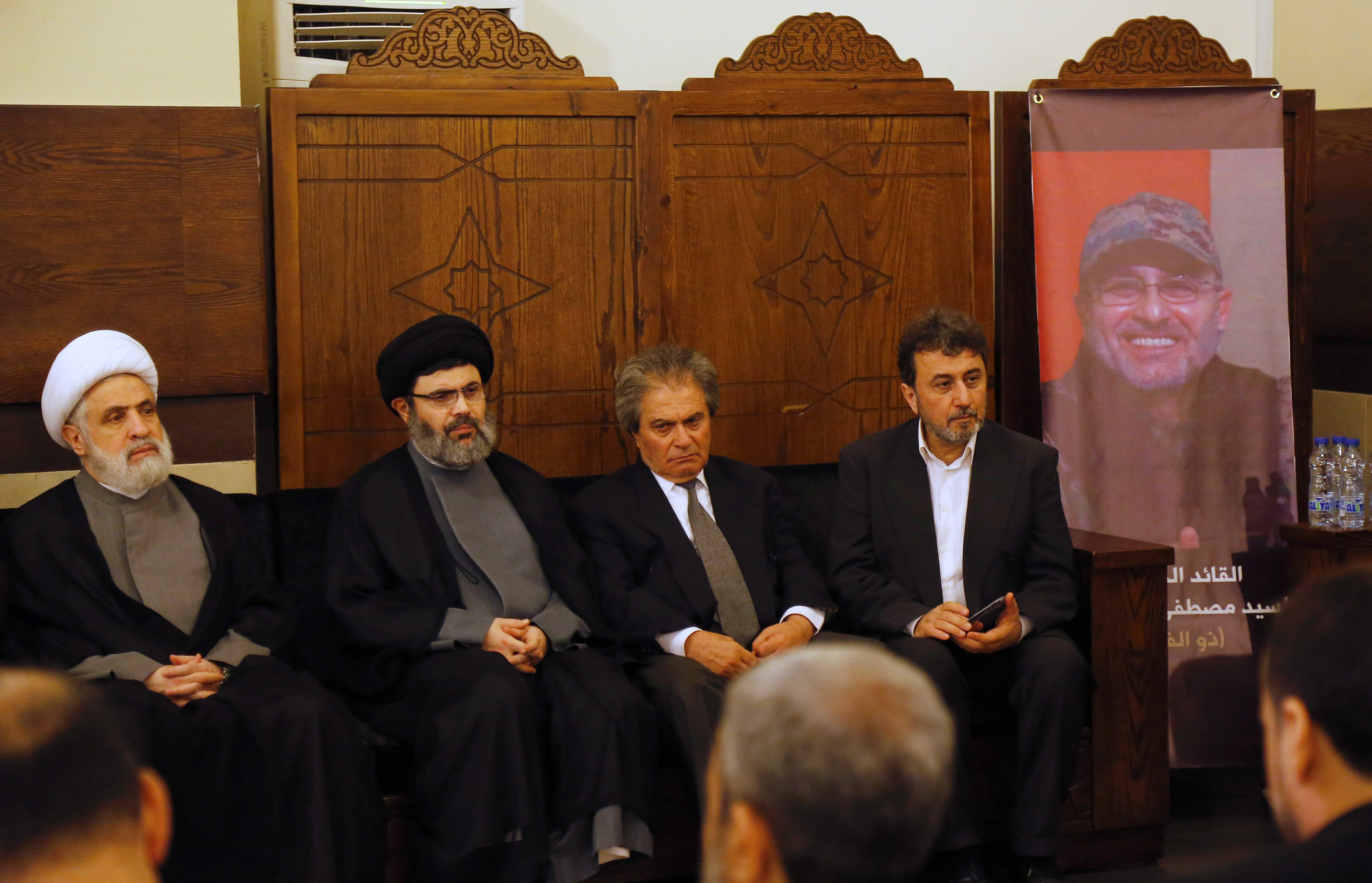 Líderes do Hezbollah e parentes do comandante Mustafa Badreddine, que foi morto em um ataque na Síria, recebem condolências em subúrbio de Beirute | ANWAR AMRO/AFP