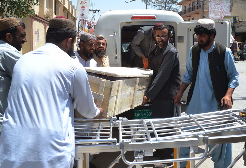 Homens fazem a retirada de corpos das vítimas do ataque de drone que matou o líder talibã; | BANARAS KHAN/AFP