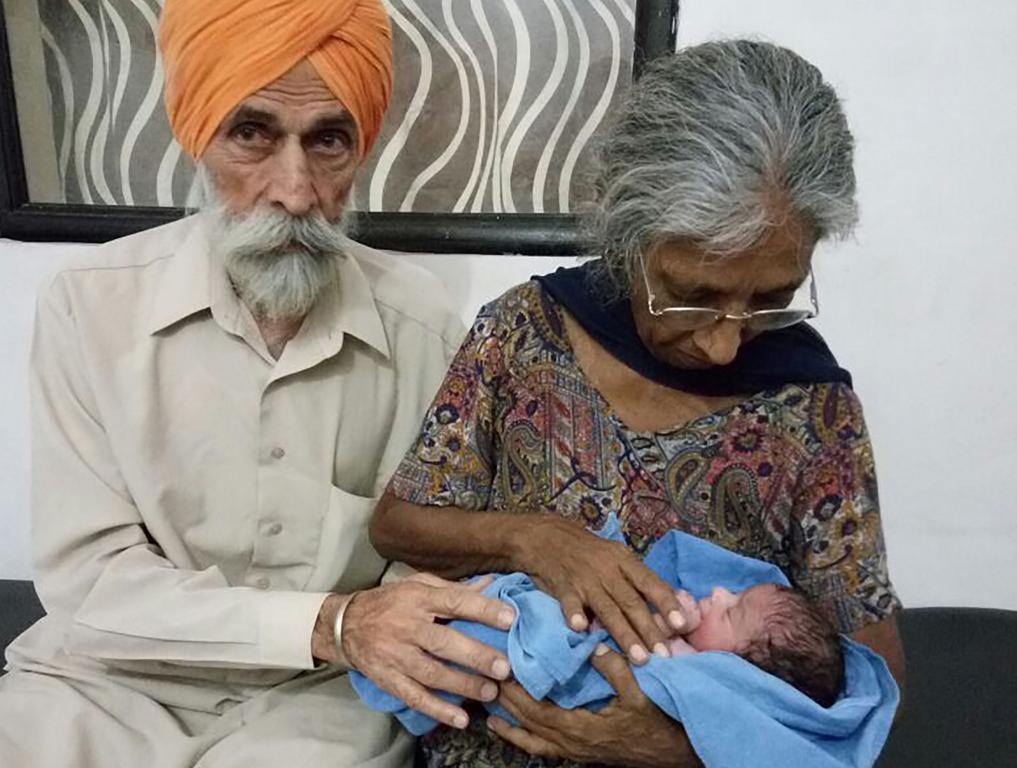 Daljinder Kaur  segura o filho recém-nascido ao lado do marido, Mohinder Singh Gill | HO/AFP