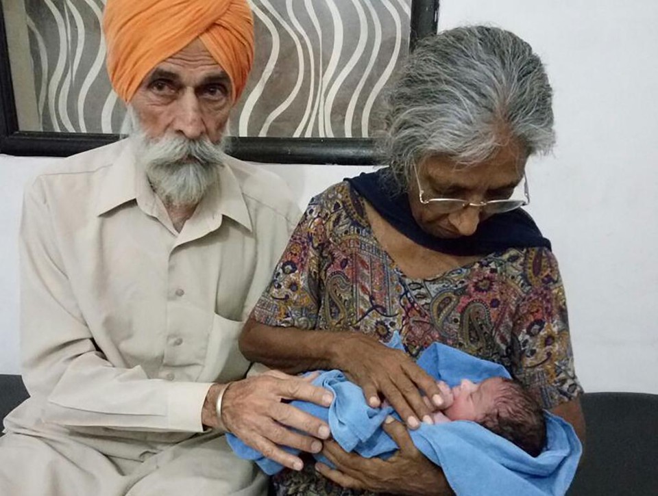 Daljinder Kaur segura o filho recém-nascido ao lado do marido, Mohinder Singh Gill | HO/AFP