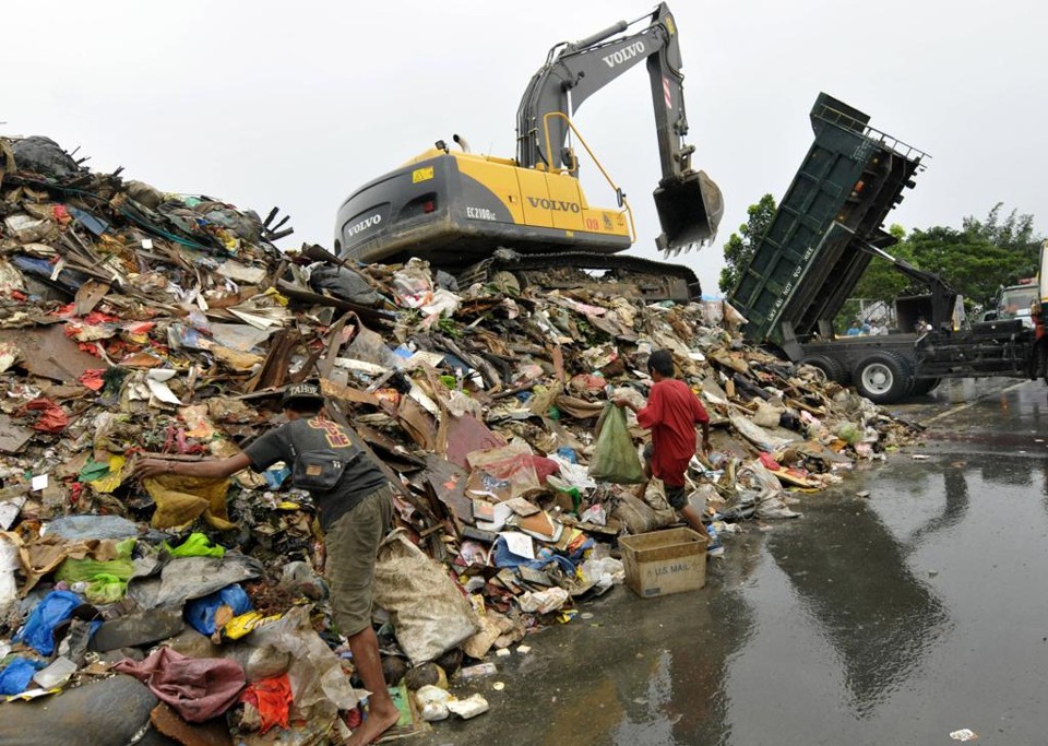 Pessoas separam o lixo em Manila, capital das Filipinas. Assim como na Indonesia, em Manila as centrais de coleta também estão virando bancos de lixo. | Arquivo/JAY DIRECTO/AFP