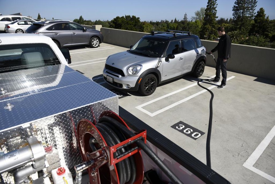 Scott Hempy, co-fundador e CEO da Filld, abastece o carro de um usuário do serviço em um estacionamento | Michael Short/Bloomberg
