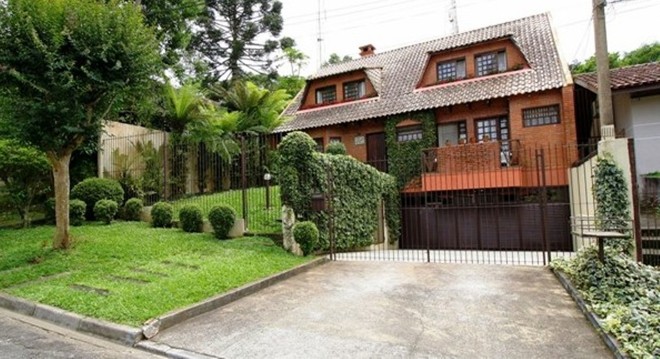 R$ 1.020.000: em estilo francês, a residência localizada no Pilarzinho tem fachada de tijolinho à vista e piso de madeira maciça e ardósia. O imóvel oferece três quartos com armários (sendo uma suíte com hidromassagem e closet) e quatro vagas de estacionamento – duas cobertas. Distribuída em três pavimentos, a planta também contempla sala para três ambientes com lareira, cozinha com armários, depósito, oficina e banheiro social. Nos fundos há uma churrasqueira com salão de festas e banheiro. O terreno conta com paisagismo e árvores frutíferas. | Divulgação