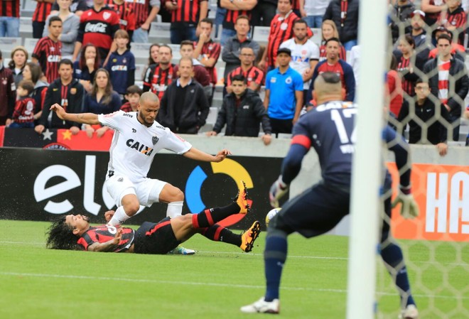 O volante Otávio se esforça para barrar o ataque do Atlético-MG na Arena da Baixada, sob o olhar atento do goleiro Weverton. | Ivonaldo Alexandre/Gazeta do Povo